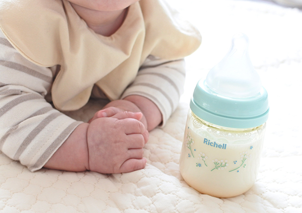 赤ちゃんの隣にある哺乳瓶