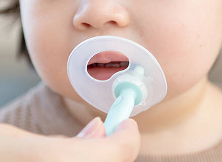 のど突き防止プレートがついたブラシで歯磨きをしている写真